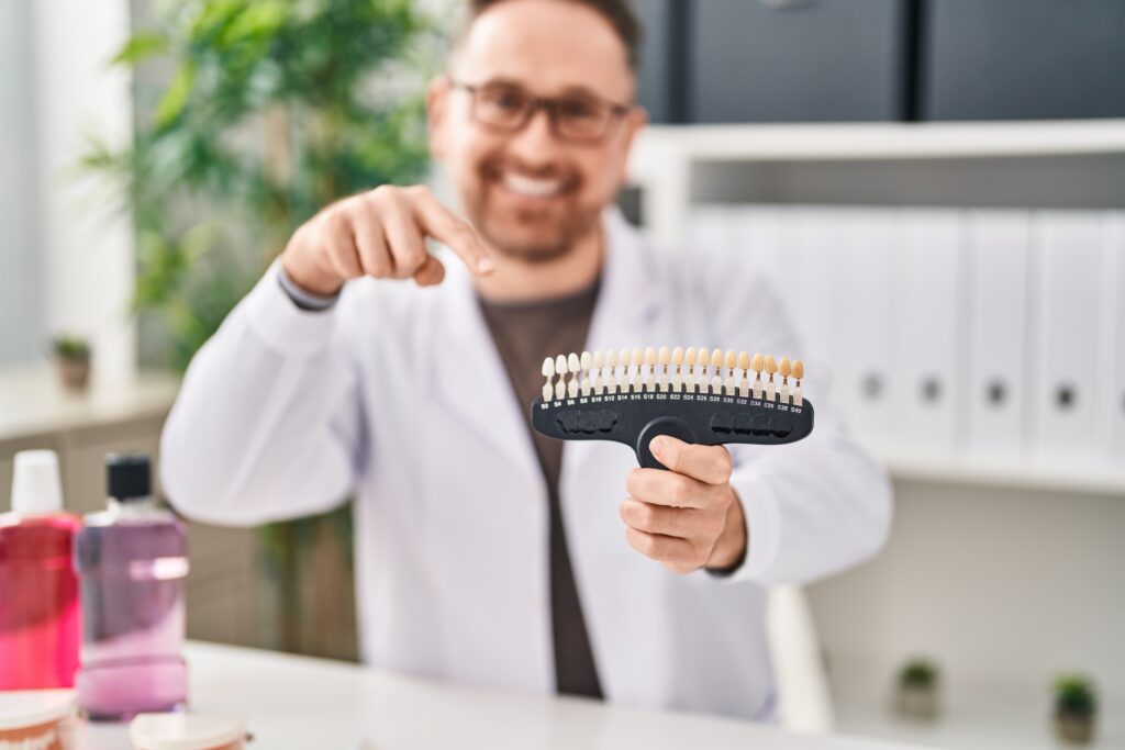 لمینت 14 young caucasian man dentist smiling confident holding whitening test clinic
